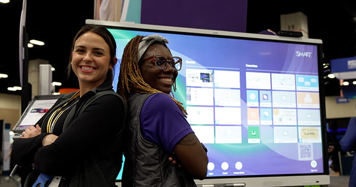 Image of two SMART employees standing in front of a SMART Board.